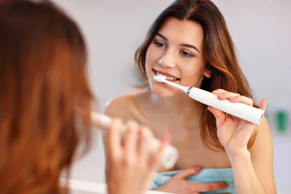 Mujer joven lavando dientes en el baño por la mañana — Foto de Stock