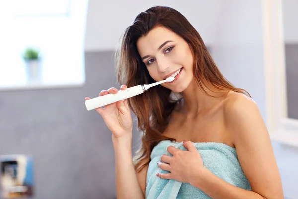 Jonge vrouw wassen van tanden in de badkamer in de ochtend — Stockfoto