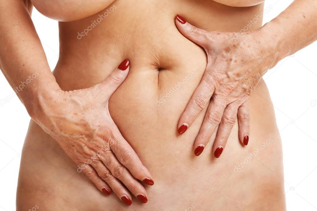 Senior woman touching abdomen over white background