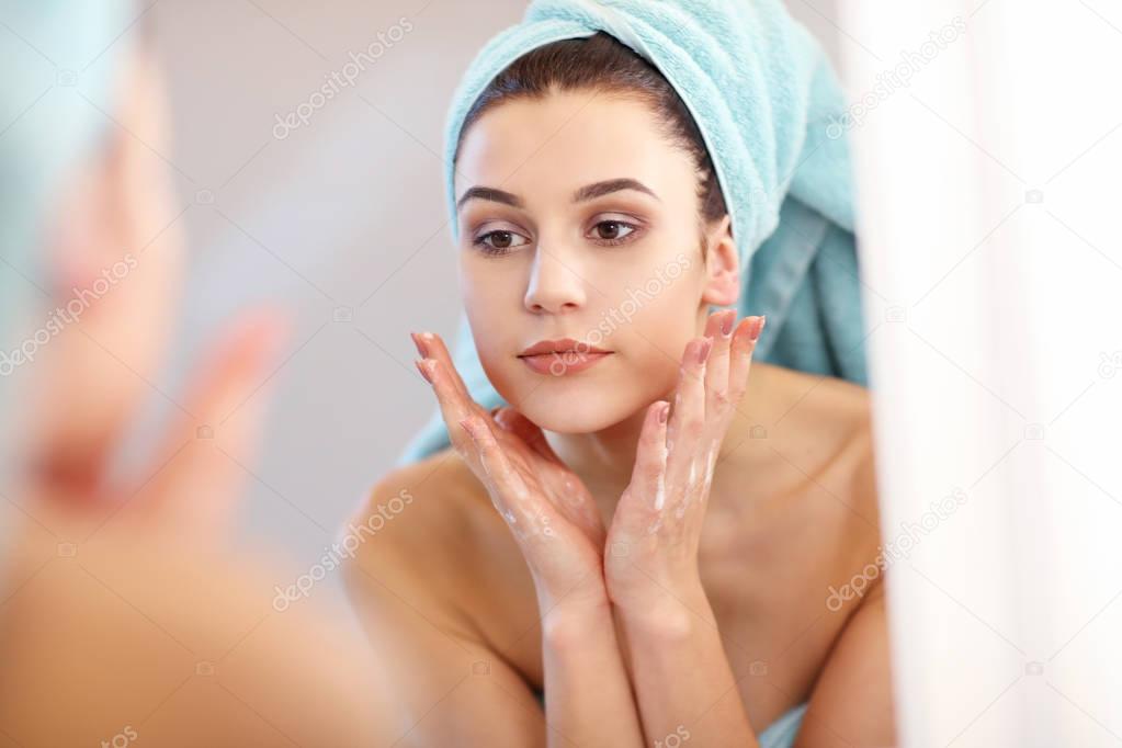 Young woman standing in bathroom in the morning