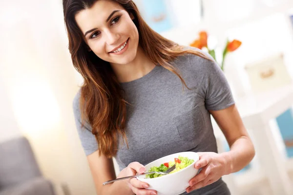 Mulher comendo salada saudável em casa — Fotografia de Stock