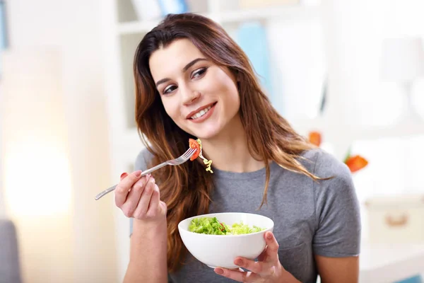 Mulher comendo salada saudável em casa — Fotografia de Stock