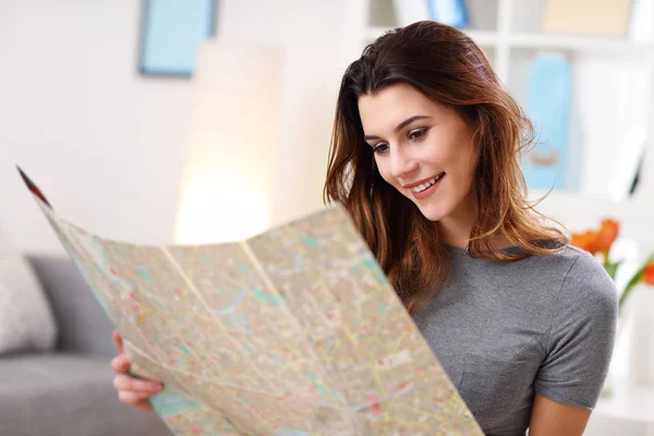 Mujer feliz con mapa en casa planificación vacaciones —  Fotos de Stock