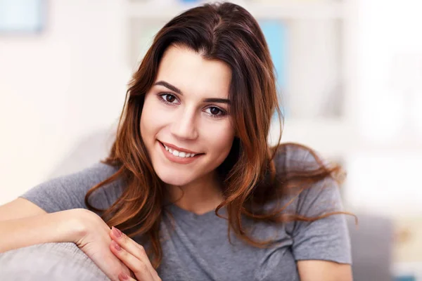 Mujer joven y relajada disfrutando del descanso en un cómodo sofá —  Fotos de Stock