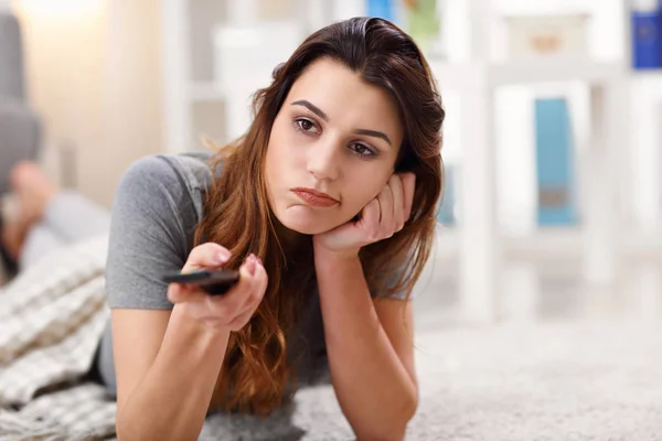 Beautiful young woman relaxing at home watching tv — Stock Photo, Image