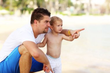 Bir baba oğlunun ile sahilde eğleniyor resim