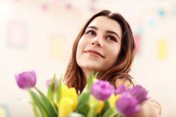 Mulher atraente organizando flores de tulipas em vaso — Fotografia de Stock