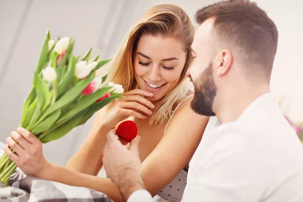 Adulto casal atraente na cama com presente — Fotografia de Stock