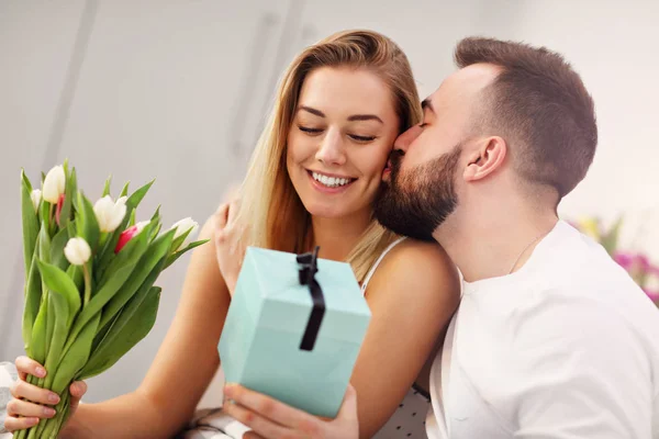 Adulto casal atraente na cama com presente — Fotografia de Stock