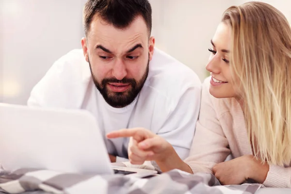 Erwachsenes Paar mit Laptop im Bett — Stockfoto