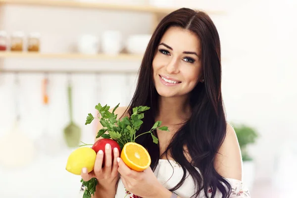 Portret van lachende jonge huisvrouw in moderne keuken — Stockfoto