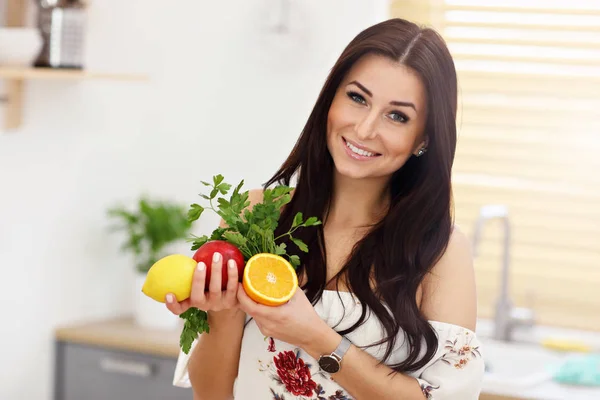 Portrait of smiling young housewife in modern kitchen — Stock Photo, Image