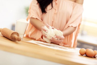 Genç kadın mutfakta bir şeyler pişirmek için çalışıyor