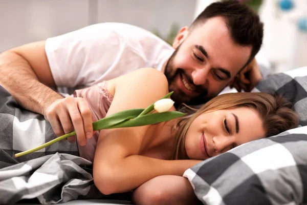 Adult attractive couple in bed with present — Stock Photo, Image