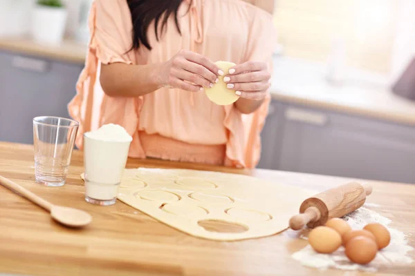 Ung kvinna försöker göra pierogi i köket — Stockfoto