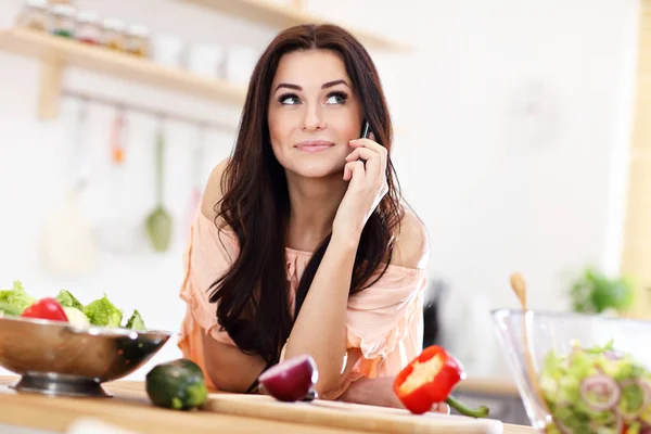 Happy woman preparing salad in modern kitchen — Stock Photo, Image