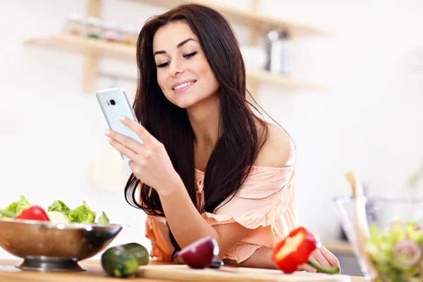 Mujer feliz preparando ensalada en la cocina moderna —  Fotos de Stock