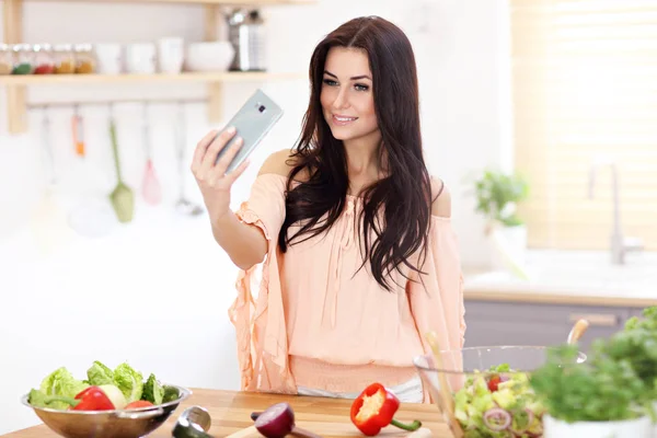 Glückliche Frau bereitet Salat in moderner Küche zu — Stockfoto