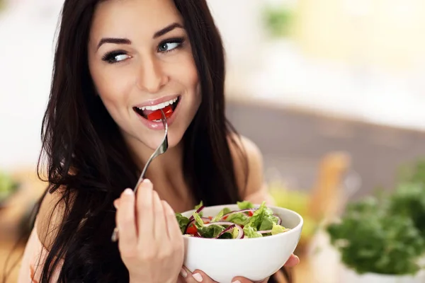 Mulher feliz preparando salada na cozinha moderna — Fotografia de Stock