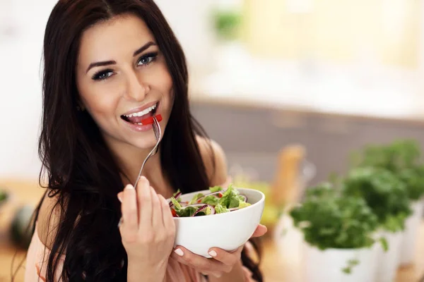 Lycklig kvinna förbereda sallad i modernt kök — Stockfoto