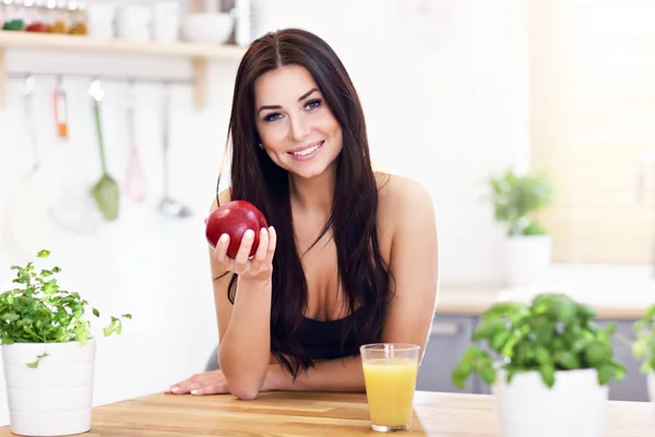 Fit lächelnde junge Frau mit gesundem Saft in moderner Küche — Stockfoto
