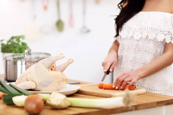 Junge Frau versucht Hühnersuppe in Küche zuzubereiten — Stockfoto