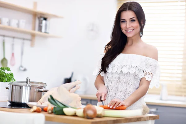 Junge Frau versucht Hühnersuppe in Küche zuzubereiten — Stockfoto