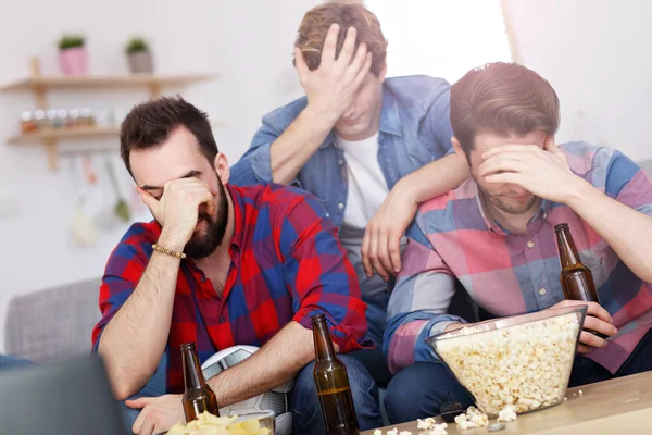 Sad male group of friends watching sports on tv at home — Stock Photo, Image