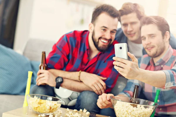 Felizes amigos do sexo masculino torcendo e assistindo esportes na tv — Fotografia de Stock