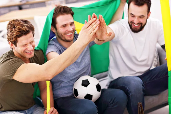 Felizes amigos do sexo masculino torcendo e assistindo esportes na tv — Fotografia de Stock
