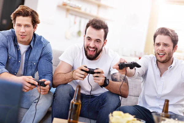 Φίλοι διασκεδάζουν στον καναπέ με τα video games — Φωτογραφία Αρχείου