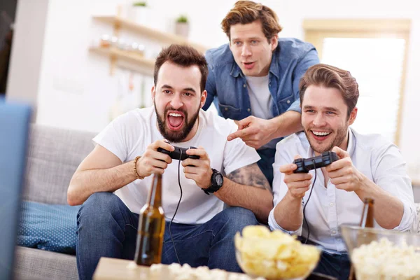 Freunde amüsieren sich auf der Couch mit Videospielen — Stockfoto
