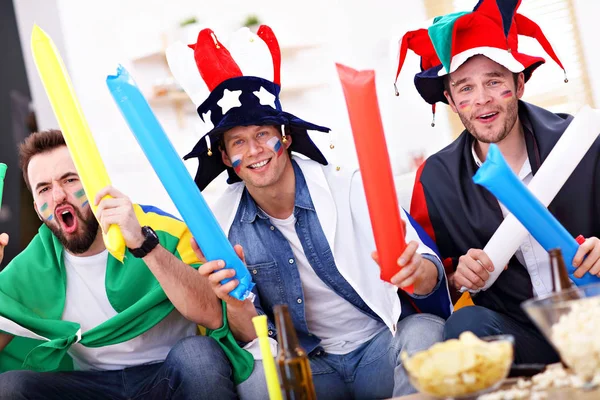 Happy male friends cheering and watching sports on tv — Stock Photo, Image