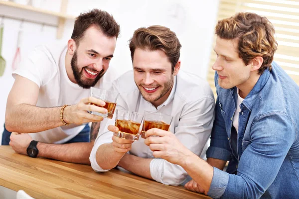 Vrolijke vrienden met plezier met smartphone en het thuis drinken — Stockfoto