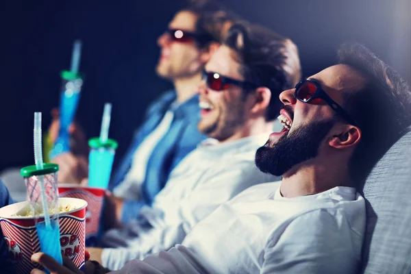 Gruppo di amici felici seduti nel cinema guardare film e mangiare popcorn — Foto Stock