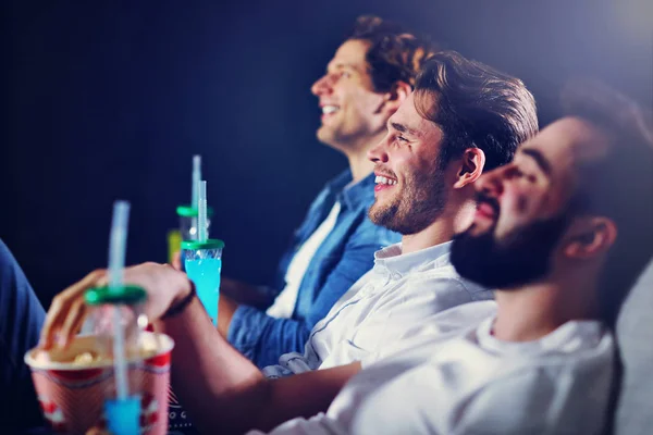 Grupo de amigos felices sentados en el cine ven películas y comen palomitas de maíz — Foto de Stock