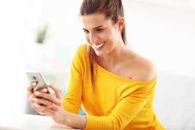 Mutlu kadın evde smartphone ile rahatlatıcı