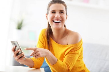 Mutlu kadın evde smartphone ile rahatlatıcı