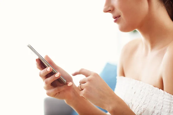 Mujer feliz relajarse en casa con teléfono inteligente —  Fotos de Stock