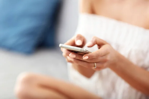 Mulher feliz relaxando em casa com smartphone — Fotografia de Stock