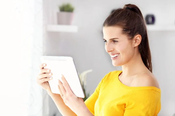 Mutlu kadın evde tablet ile rahatlatıcı — Stok fotoğraf