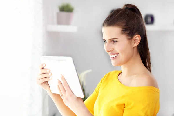 Mulher feliz relaxando em casa com tablet — Fotografia de Stock