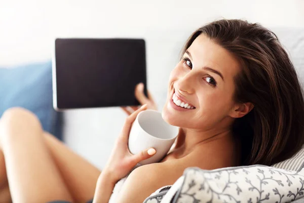 Счастливая женщина отдыхает дома с планшетом — стоковое фото