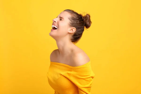 黄色の背景に顔を作る女性の画像 — ストック写真
