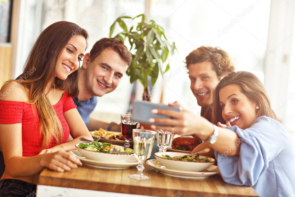 Group Of Young Friends Enjoying Meal In Restaurant