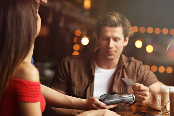 Linda pareja en una cita en el café pagando con tarjeta de crédito — Foto de Stock