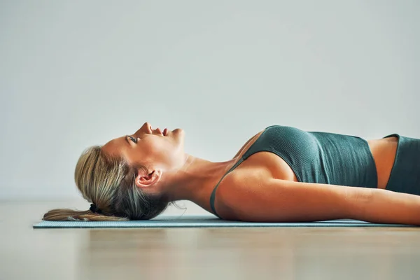 Volwassen vrouw die thuis yoga beoefent — Stockfoto