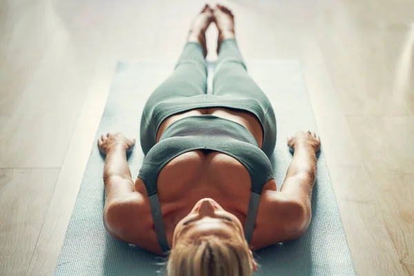 Erwachsene Frau praktiziert Yoga zu Hause — Stockfoto
