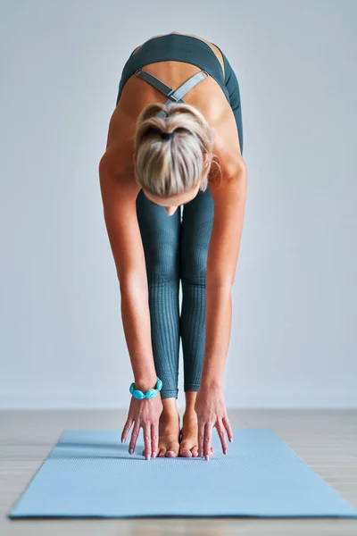 Vuxen kvinna som utövar yoga hemma — Stockfoto