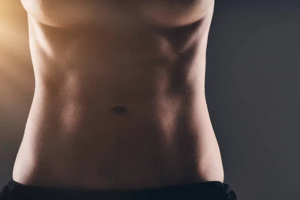 Mujer sexy abdomen sobre fondo oscuro — Foto de Stock